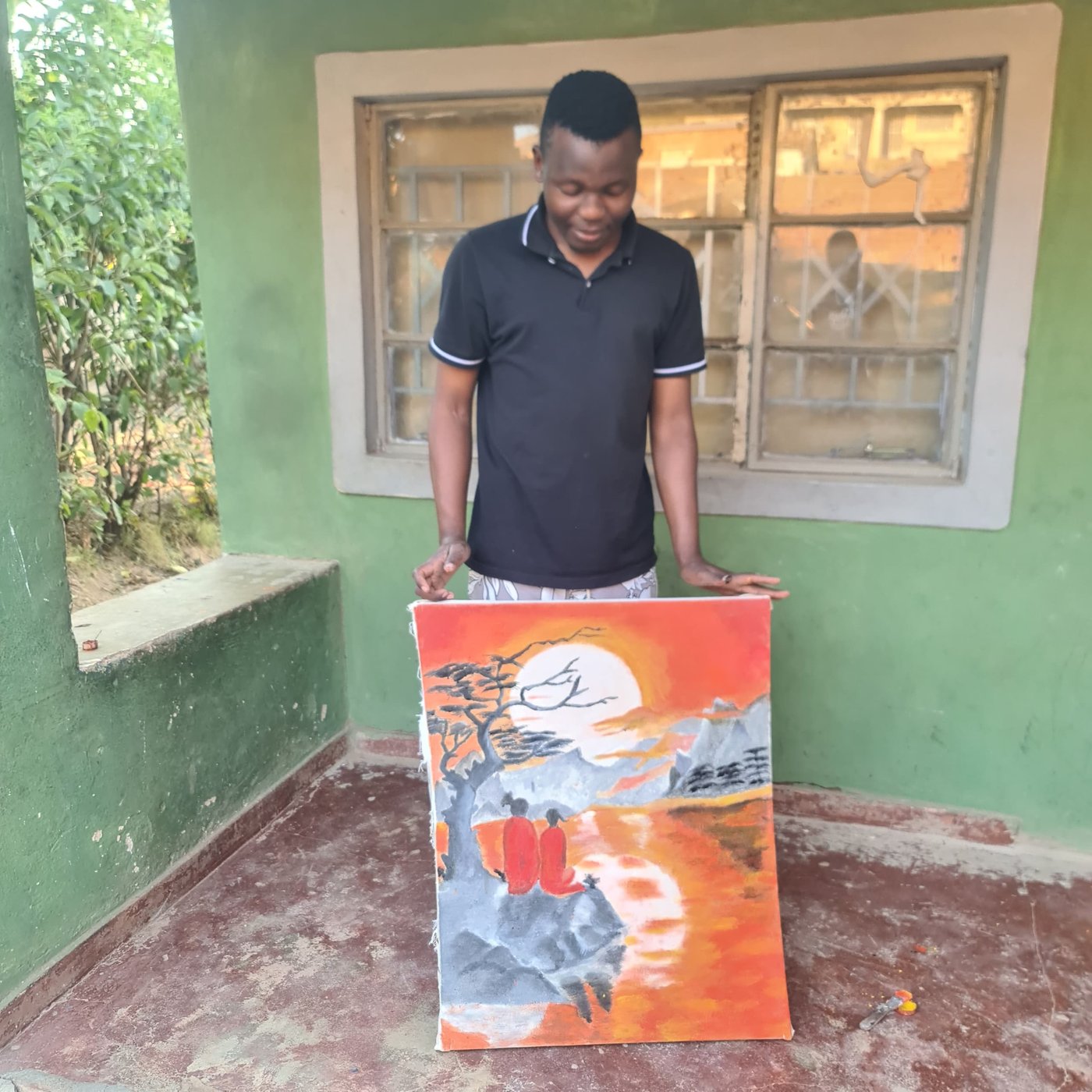 Edgar Mbalame presenting an original canvas landscape painting